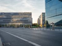 an empty street with buildings in the background at sunset of a city street at dusk