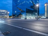 a building with a car driving past in front of it at dusk during the day