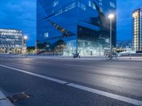 a building with a car driving past in front of it at dusk during the day