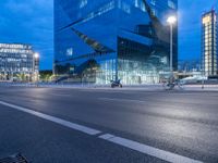 a building with a car driving past in front of it at dusk during the day