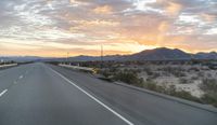 a highway has been blocked off by traffic on it at dusk with mountain views behind