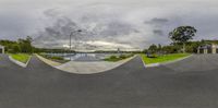 a panoramic view of skateboards in a parking lot at dusk with some cars and buildings