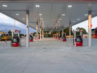 empty gas station at dusk with machines and equipment in the center of the station,