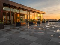 large brick tiles with potted plants on them at dusk in a building with sunset