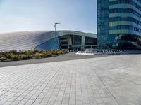 some people sitting on a bench in front of a building on a sunny day with blue skies