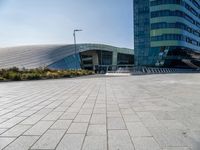 some people sitting on a bench in front of a building on a sunny day with blue skies