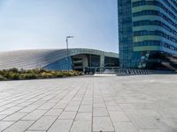 some people sitting on a bench in front of a building on a sunny day with blue skies