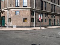 a red no left turn sign next to an empty street in a city environment of brick