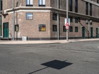 a red no left turn sign next to an empty street in a city environment of brick