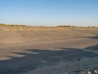 the sign is marked in yellow on a deserted runway at an airport by a beach