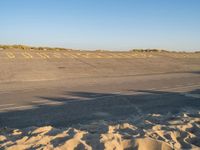 the sign is marked in yellow on a deserted runway at an airport by a beach