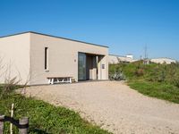 the building with two benches is empty of people in it's own area in the countryside