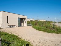 the building with two benches is empty of people in it's own area in the countryside