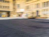 a blurry photograph of an urban area with buildings and a person riding a bike