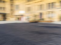 a blurry photograph of an urban area with buildings and a person riding a bike