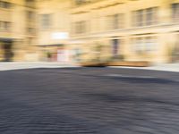 a blurry photograph of an urban area with buildings and a person riding a bike