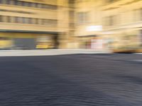 a blurry photograph of an urban area with buildings and a person riding a bike