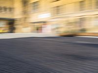 a blurry photograph of an urban area with buildings and a person riding a bike