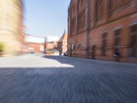 a blurry photograph of buildings and a car on the sidewalk of an old city