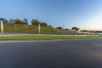 a person riding a motorcycle on a race track with trees in the background at sunset