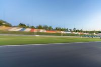 a person riding a motorcycle on a race track with trees in the background at sunset