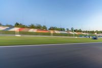 a person riding a motorcycle on a race track with trees in the background at sunset