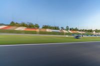 a person riding a motorcycle on a race track with trees in the background at sunset