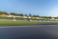 a person riding a motorcycle on a race track with trees in the background at sunset