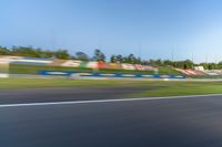 a person riding a motorcycle on a race track with trees in the background at sunset