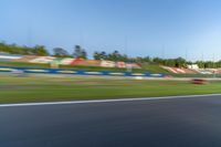 a person riding a motorcycle on a race track with trees in the background at sunset