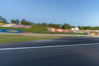 a person riding a motorcycle on a race track with trees in the background at sunset