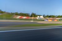 a person riding a motorcycle on a race track with trees in the background at sunset