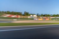 a person riding a motorcycle on a race track with trees in the background at sunset