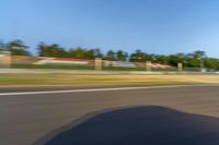 a person riding a motorcycle on a race track with trees in the background at sunset