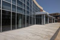 a long building has many windows on each side of it, and the large white umbrella is hanging from it's pole