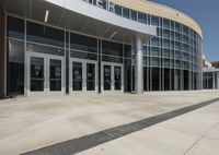 the front entrance of a large building with glass doors and a white trim around it