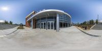 a view looking into an outdoor arena through a fish eye lens mirror as a person rides a skateboard