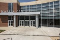 the front of martin center in a school with a bench outside of it and large windowed windows