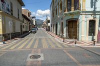 a small city street has parked cars on it, and no sidewalks are shown here