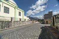 an empty paved street in the middle of town on a bright sunny day at a building