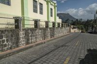 an empty paved street in the middle of town on a bright sunny day at a building