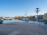 the water is very calm and full of boats and buildings in the distance for a clear blue sky