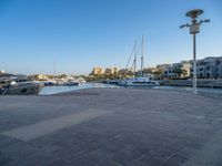 the water is very calm and full of boats and buildings in the distance for a clear blue sky