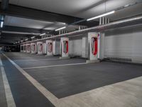 a long, empty garage with some red and white electrical outlets on the wall and floor