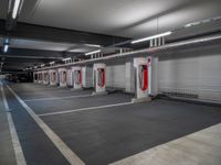 a long, empty garage with some red and white electrical outlets on the wall and floor