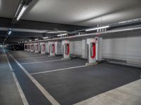 a long, empty garage with some red and white electrical outlets on the wall and floor