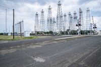 several electric towers that are in the middle of a street in front of a factory