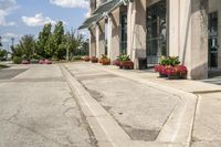 several flower pots sit in front of this very elegant building on the sidewalk outside the window