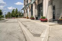 several flower pots sit in front of this very elegant building on the sidewalk outside the window