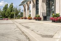 several flower pots sit in front of this very elegant building on the sidewalk outside the window